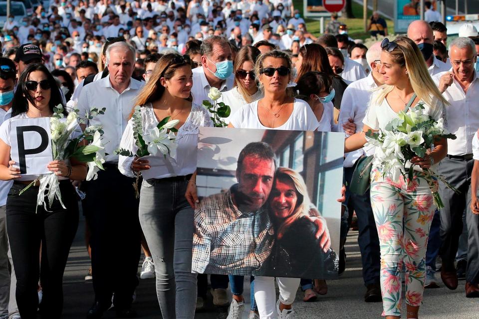 Veronique Monguillot holds a photo of her with her husband during a protest march in Bayonne (AP)