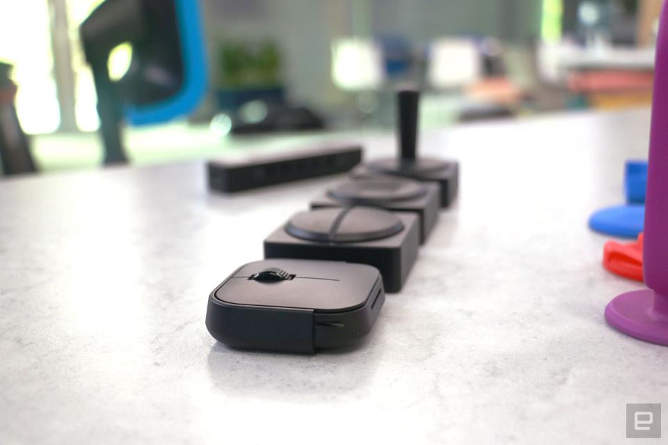 <p>Side view of the Microsoft Adaptive Mouse and three Buttons, laid out in a line.</p>
