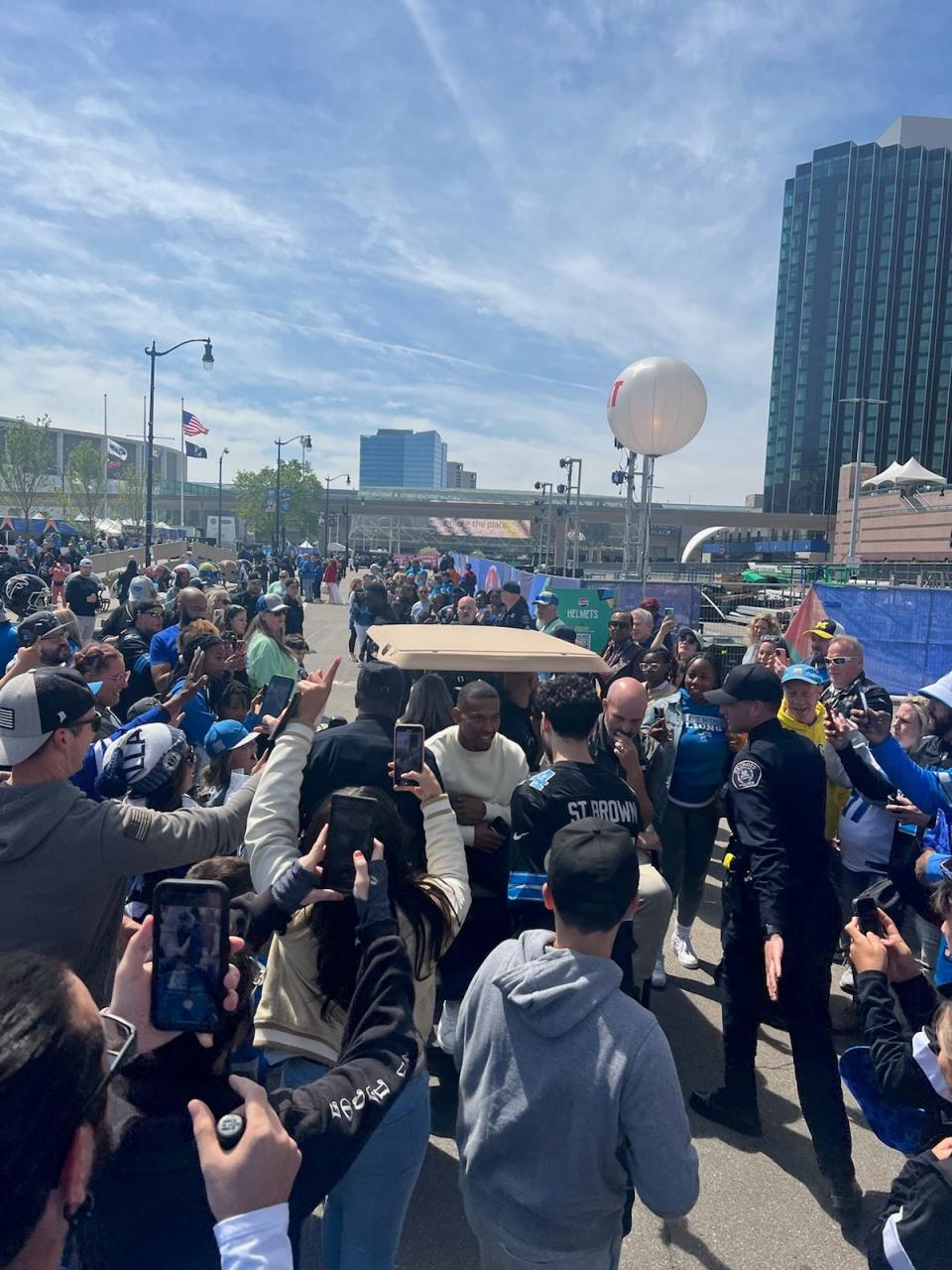 Detroit Lions star wide receiver Amon-Ra St. Brown makes his way through the crowd on a golf cart during festivities related to the NFL draft Friday