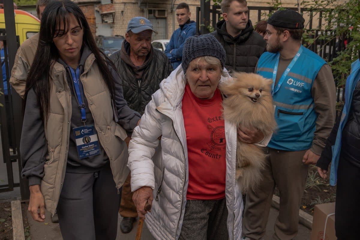 Olga Garmash (C), 68, an evacuee from the village of Lyptsi, arrives with her dog at an evacuation point in Kharkiv, on May 11 (AFP via Getty Images)