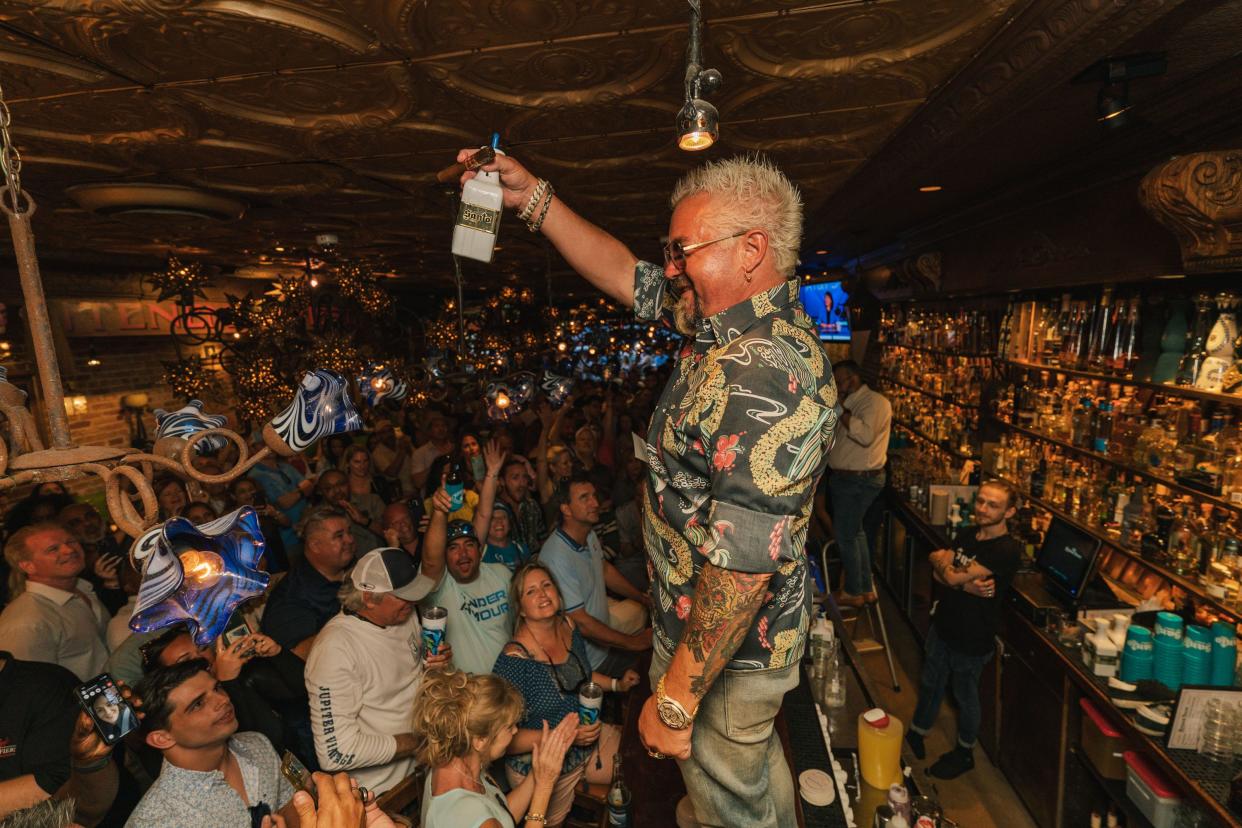 Celebrity chef Guy Fieri pouring shots of Santos Tequila during an after party at Rocco's Tacos in West Palm Beach.