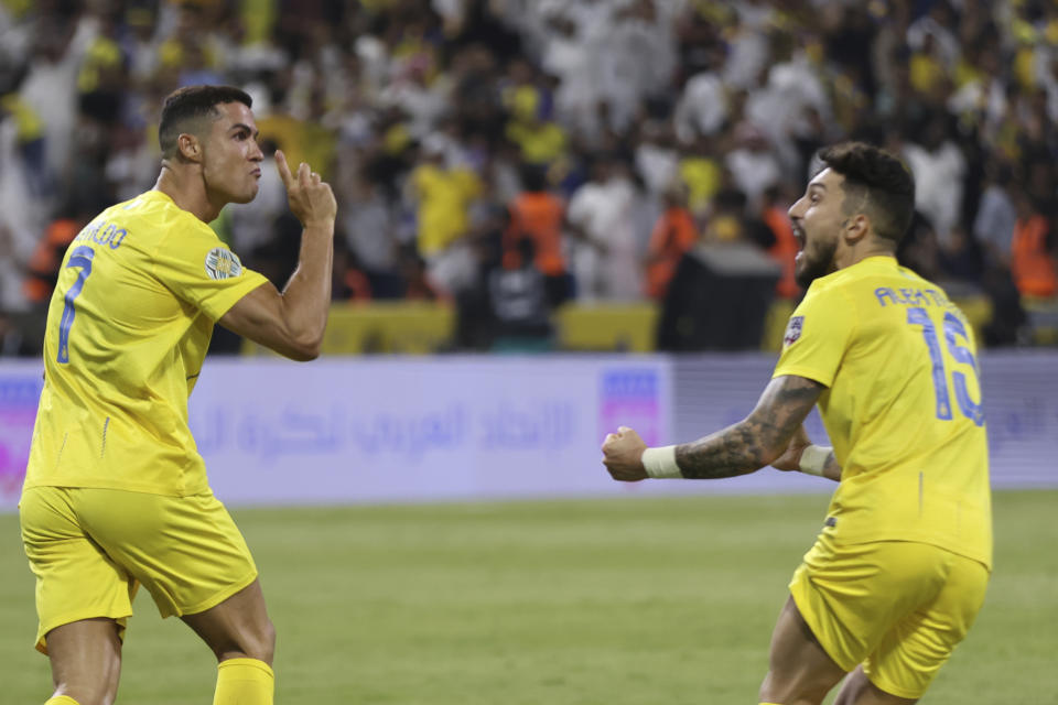 Al-Nassr's Cristiano Ronaldo, and Alex Telles, right, celebrate a goal against Al-Hilal during the Arab Club Champions Cup at King Fahd Stadium in Taif, Saudi Arabia, Saturday, Aug. 12, 2023. (AP Photo/Samah Zidan)