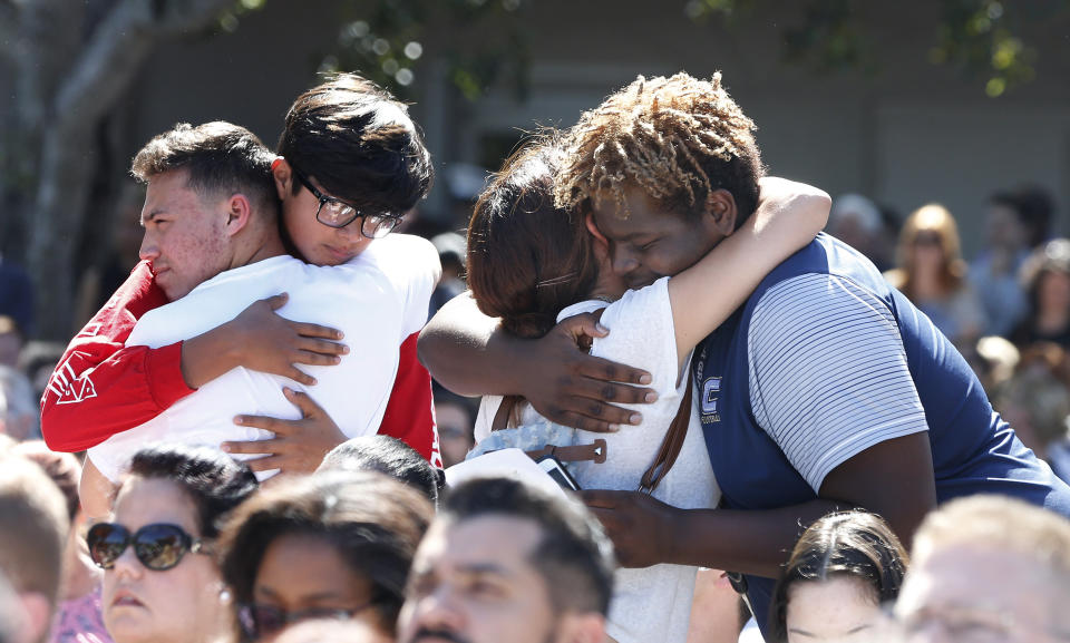 Mourners hug.