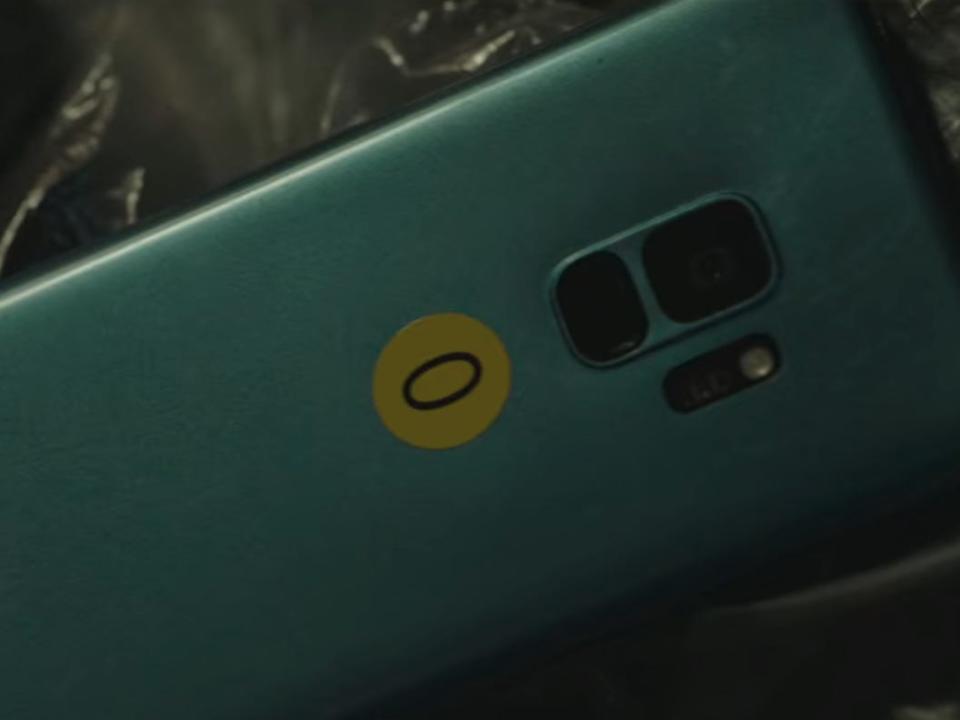 a blue cellphone in unlocked labeled with a yellow sticker that has the number zero on it