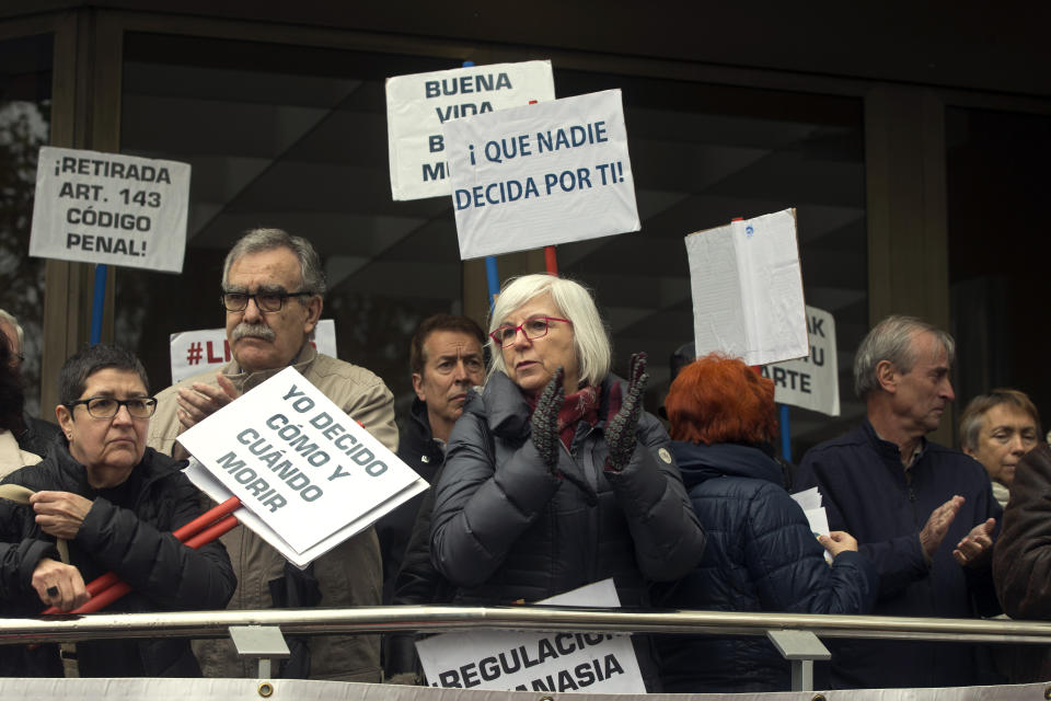 People applaud during a protest outside one of the main courts in Madrid, Spain, Friday, April 5, 2019. A Madrid court has released Angel Hernandez, a 70-year-old man who admitted to helping his 61-year-old wife end her life and who was diagnosed 30 years ago with multiple sclerosis and had for years asked him to help her die. The case has reignited a national debate in Spain about assisted suicide. Main banners read 'Nobody decides for me'. 'I decide how and when to die'. (AP Photo/Paul White)