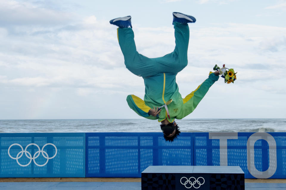 Brazil's Italo Ferreira, holding his gold medal, celebrates on the podium in the men's surfing competition at the 2020 Summer Olympics, Tuesday, July 27, 2021, at Tsurigasaki beach in Ichinomiya, Japan. (Olivier Morin/Pool Photo via AP)