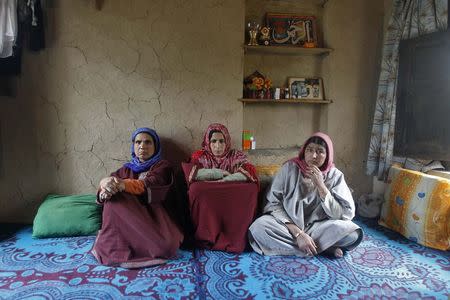 Saheema Akhtar (C), wife of Mohammed Amin Pandith, a village council head, who was killed by militants, sits with relatives inside her house in Gulzarpora, south of Srinagar April 23, 2014. REUTERS/Danish Ismail