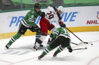 Dallas Stars defenseman Jamie Oleksiak (2) and center Jason Dickinson (18) try to get the puck away from Columbus Blue Jackets right wing Patrik Laine (29) during the first period of an NHL hockey game Thursday, April 15, 2021, in Dallas. (AP Photo/Richard W. Rodriguez)