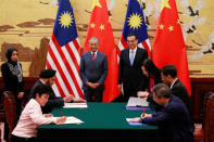 Malaysia's Prime Minister Mahathir Mohamad and China's Premier Li Keqiang watch as delegates sign documents during a signing ceremony at the Great Hall of the People in Beijing, China, August, 20, 2018. How Hwee Young/Pool via REUTERS