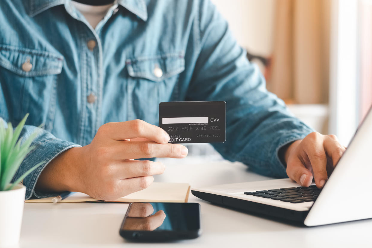 Businessman hand holding credit card with using laptop for online shopping while making orders at home. business, lifestyle, technology, ecommerce, digital banking and online payment concept.