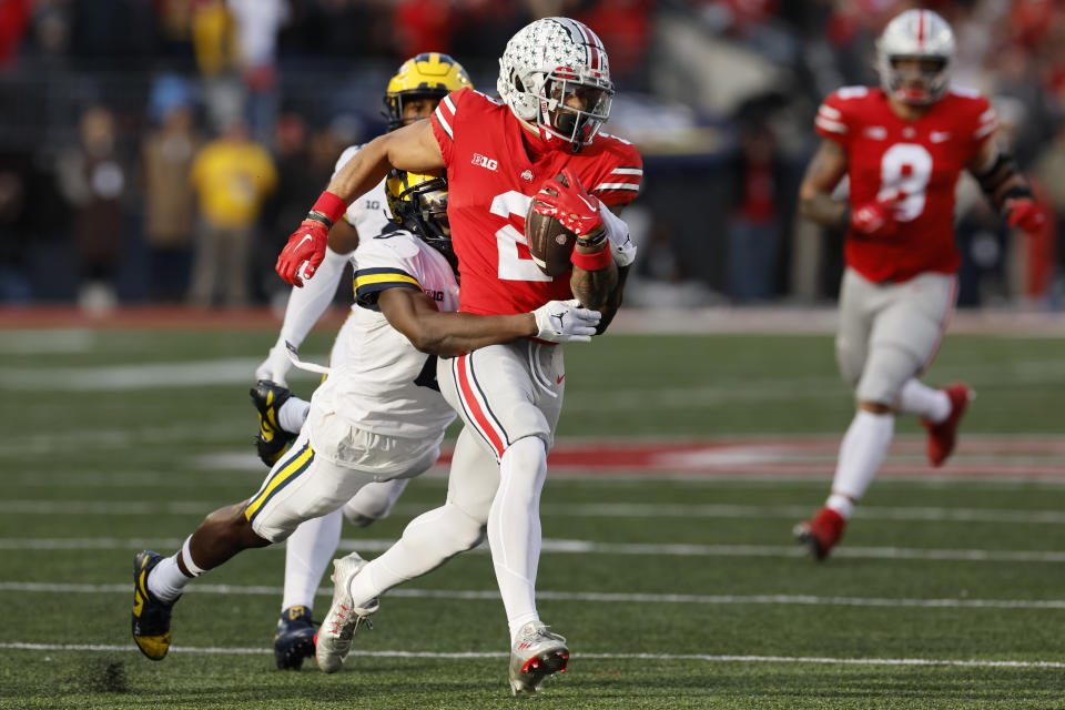 Michigan defensive back Mike Sainristil, left, tackles Ohio State receiver Emeka Egbuka during the second half of an NCAA college football game on Saturday, Nov. 26, 2022, in Columbus, Ohio. (AP Photo/Jay LaPrete)