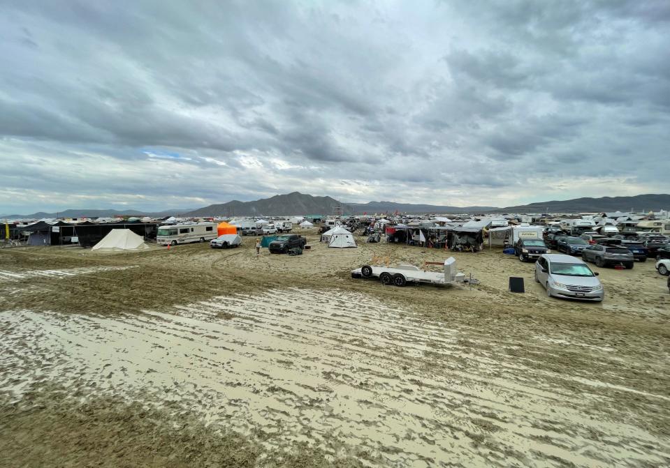 Camps are set on a muddy desert plain on September 2, 2023, after heavy rains turned the annual Burning Man festival site in Nevada's Black Rock desert into a mud pit. / Credit: JULIE JAMMOT/AFP via Getty Images