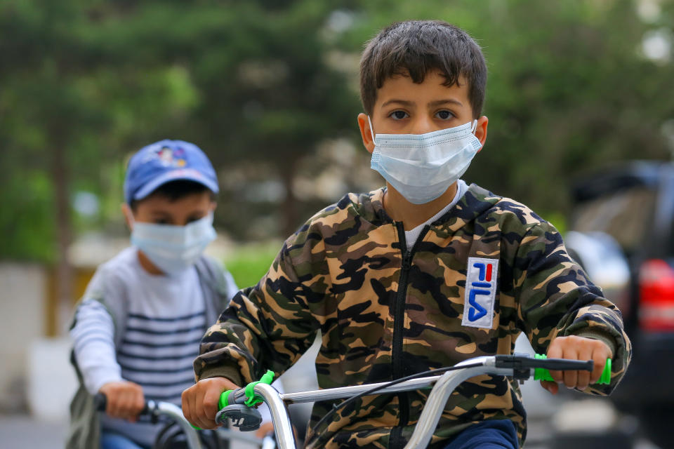 BAKU, AZERBAIJAN - MAY 21: A boy rides a bicycle with a protective mask after Azerbaijani government started to ease some restrictions caused by the novel coronavirus (COVID-19) pandemic on May 21, 2020 in Baku, Azerbaijan. The coronavirus outbreak has infected more than 5  million people across the world. Azerbaijan has reported 3749 cases of COVID-19 and 44 deaths.(Photo by Aziz Karimov/Getty Images)