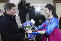 Oleg Kozhemyako, Russia's governor of the Maritime Territory Administration, receives a bouquet of flowers from a North Korean woman after he arrived at the Pyongyang International airport in Pyongyang, North Korea, Monday, Dec. 11, 2023. (AP Photo/Jon Chol Jin)