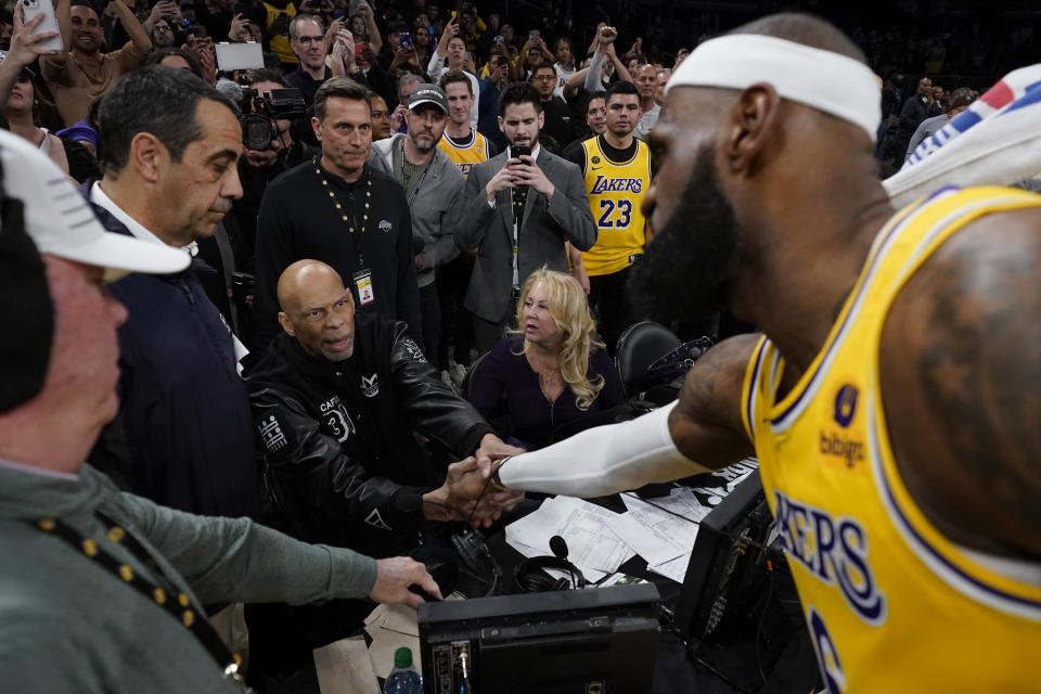 Los Angeles Lakers forward LeBron James, right, shakes hands with Kareem Abdul-Jabbar, center, after James beat Abdul-Jabbar's record to become the NBA's all-time leading scorer during the second half of an NBA basketball game against the Oklahoma City Thunder Tuesday, Feb. 7, 2023, in Los Angeles. (AP Photo/Ashley Landis)