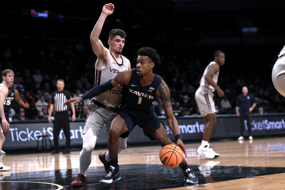 Xavier's Paul Scruggs (1) drives past Virginia Tech's Hunter Cattoor during the first half of an NCAA college basketball game in the NIT Season Tip-Off tournament Friday, Nov. 26, 2021, in New York. (AP Photo/Adam Hunger)