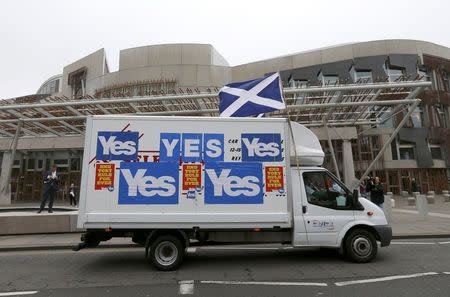 A van covered in 'Yes' campaign posters drives past the Scottish Parliament building in Edinburgh, in Scotland September 17, 2014. REUTERS/Russell Cheyne
