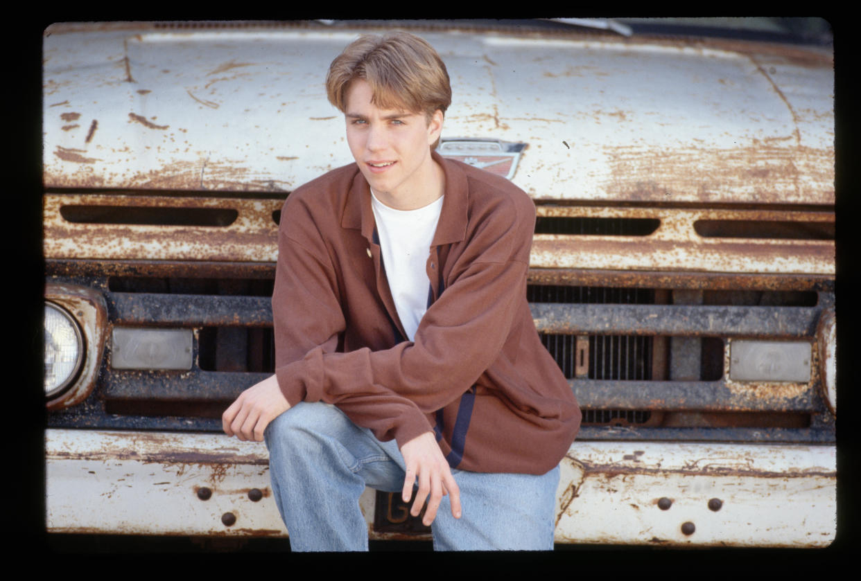 (Original Caption) : 1994-Actor Jonathan Brandis is shown leaning on the front bumper of a rusty old truck.   (Photo by Lynn Goldsmith/Corbis/VCG via Getty Images)