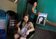 Mother of late Honduran migrant Herrera holds a framed picture at her home in El Limon