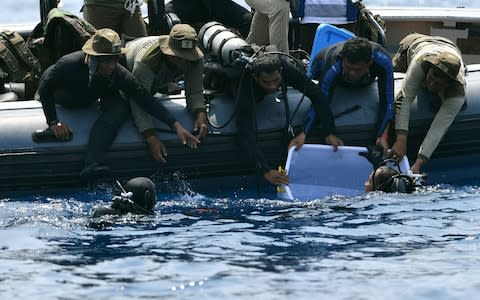 Divers recover the black box from the wreckage of the Lion Air plane - Credit: Adek Berry/AFP