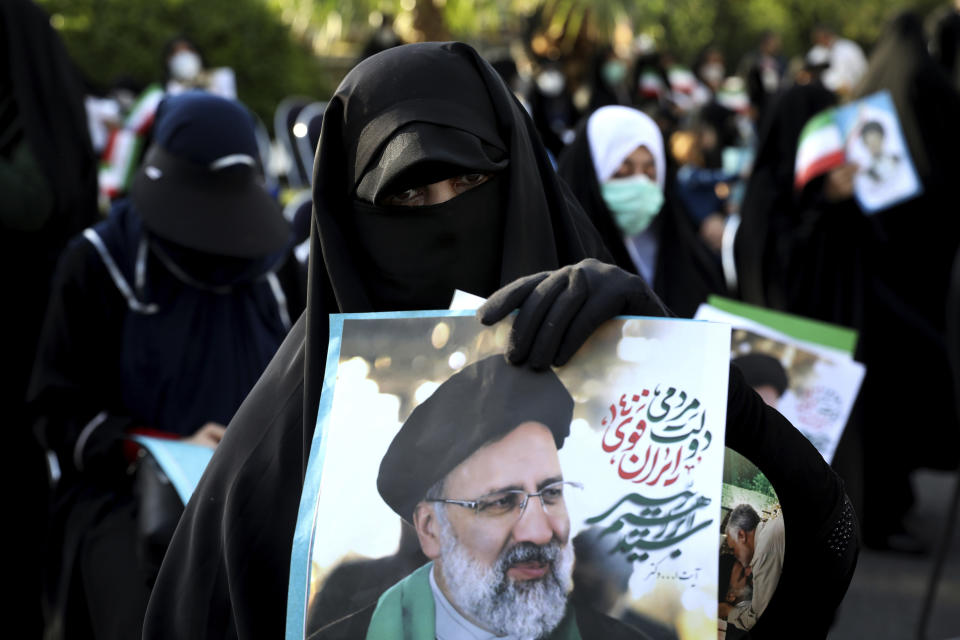 A supporter of presidential candidate Ebrahim Raisi holds a sign during a rally in Tehran, Iran, Wednesday, June 16, 2021. Iran's clerical vetting committee has allowed just seven candidates for the Friday, June 18, ballot, nixing prominent reformists and key allies of President Hassan Rouhani. The presumed front-runner has become Ebrahim Raisi, the country's hard-line judiciary chief who is closely aligned with Supreme Leader Ayatollah Ali Khamenei. (AP Photo/Ebrahim Noroozi)
