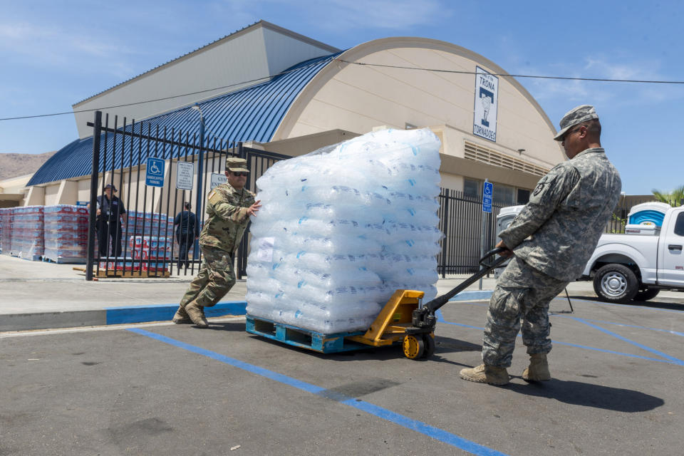 National Guard members distribute free ice to residents in Trona, Calif., on Tuesday July 9, 2019. Charities and governmental agencies ramped up recovery efforts in the small town ravaged by earthquakes and aftershocks. It could be several more days before water service is restored to the tiny town of Trona, where officials trucked in portable toilets and showers. (James Quigg/The Daily Press via AP)