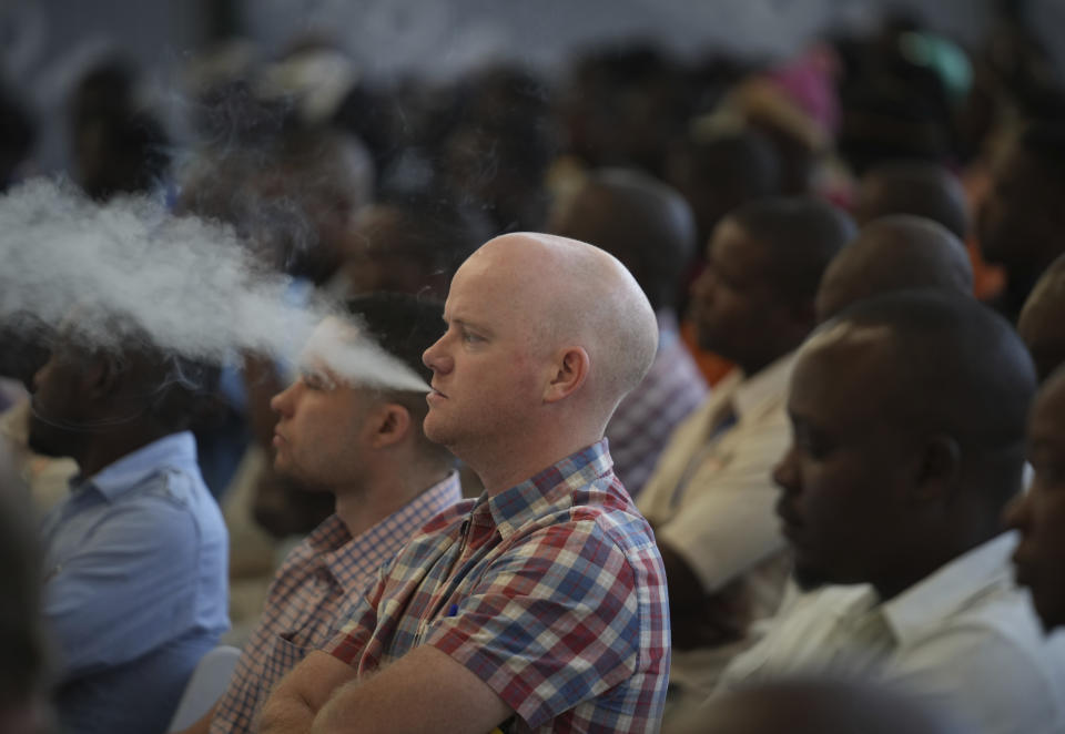 A man vapes during the opening of the tobacco selling season in Harare, Zimbabwe, Wednesday, March 13, 2024. Zimbabwe one of the worlds largest tobacco producers, on Wednesday opened its tobacco selling season. Officials and farmers said harvests and the quality of the crop declined due to a drought blamed on climate change and worsened by the El Niño weather phenomenon.(AP Photo/Tsvangirayi Mukwazhi)