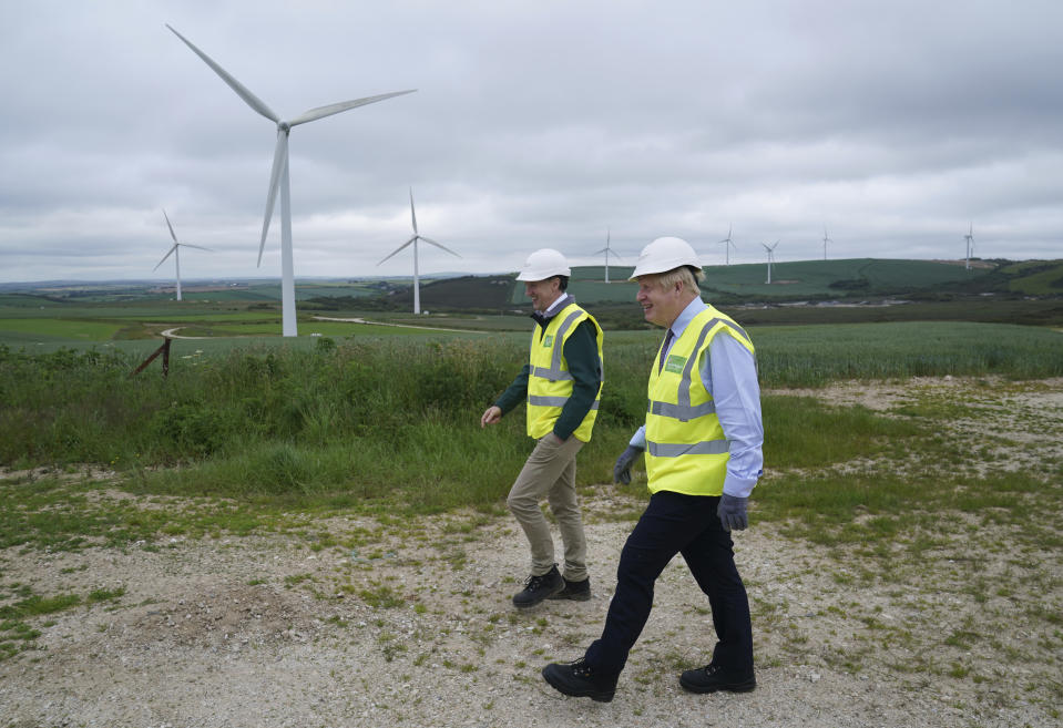 FILE - In this June 9, 2021, file photo, British Prime Minister Boris Johnson, right, visits the Scottish Power Carland Cross Windfarm to view new construction on a solar farm in Newquay, Cornwall, England. Leaders of some of the world’s richest nations will be meeting at the English seaside for a three-day Group of Seven summit in a world that has changed hugely since their last gathering two years ago. Before the pandemic, Johnson planned this to be a climate-dominated summit. (AP Photo/Jon Super, Pool, File)