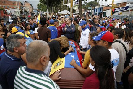 Relatives and mourners stand around the coffin of Jimmy Vargas, a student who died in a a protest, during his funeral in San Cristobal, about 410 miles (660 km) southwest of Caracas, February 26, 2014. REUTERS/Carlos Garcia Rawlins