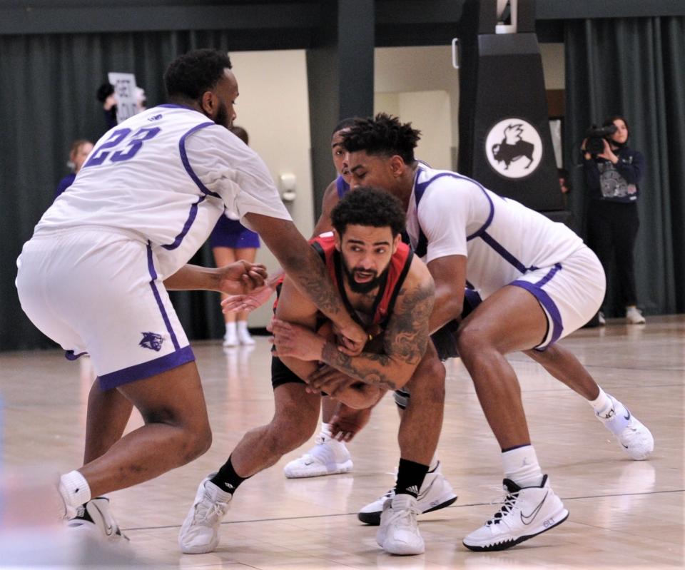 ACU's Immanuel Allen, right, and Airion Simmons, left, tie up Seattle's Kyree Brown in the second half. The play gave ACU the ball trailing 62-50 with 2:29 left in the game.