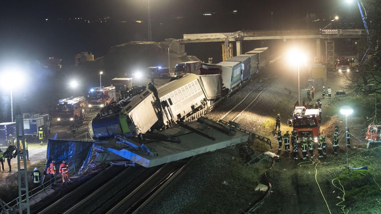 Feuerwehrfahrzeuge stehen um den verunglückten Zug.