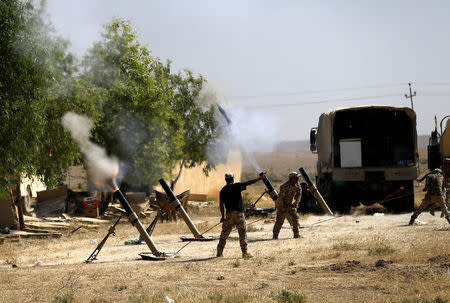 Members of Iraqi Army fire mortar shells during the war between Iraqi army and Shi'ite Popular Mobilization Forces (PMF) against the Islamic State militants in al-Ayadiya, northwest of Tal Afar, Iraq August 28, 2017. REUTERS/Thaier Al-Sudanii