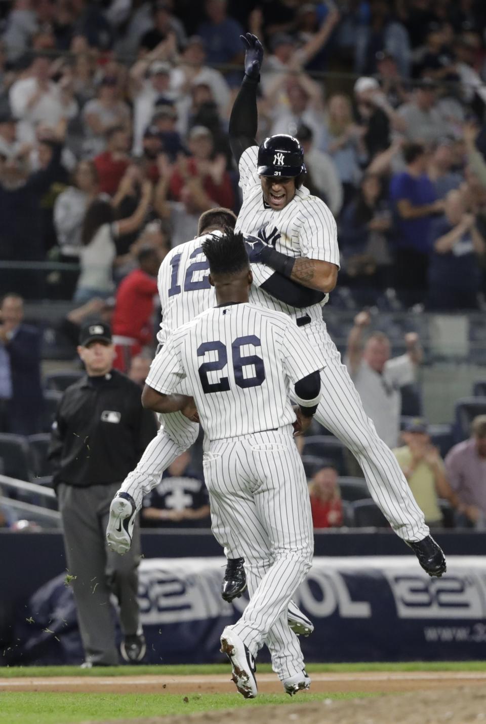 New York Yankees' Aaron Hicks celebrates with teammates Tyler Wade (12) and Andrew McCutchen (26) after hitting an RBI double during the eleventh inning of a baseball game against the Baltimore Orioles Saturday, Sept. 22, 2018, in New York. The Yankees won 3-2. (AP Photo/Frank Franklin II)