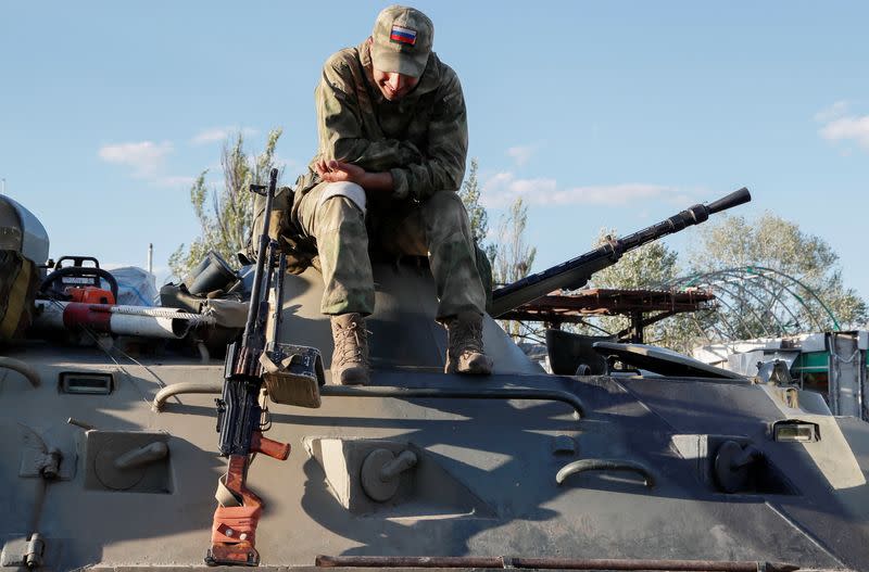 Service members of pro-Russian troops stand guard in Mariupol