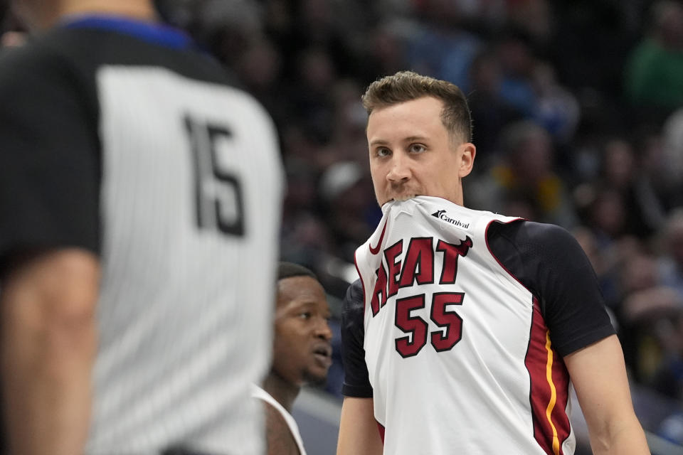 Miami Heat forward Duncan Robinson (55) bites his jersey after being called for a foul by referee Zach Zarba (15) during the first half of an NBA basketball game against the Dallas Mavericks in Dallas, Thursday, March 7, 2024. (AP Photo/LM Otero)