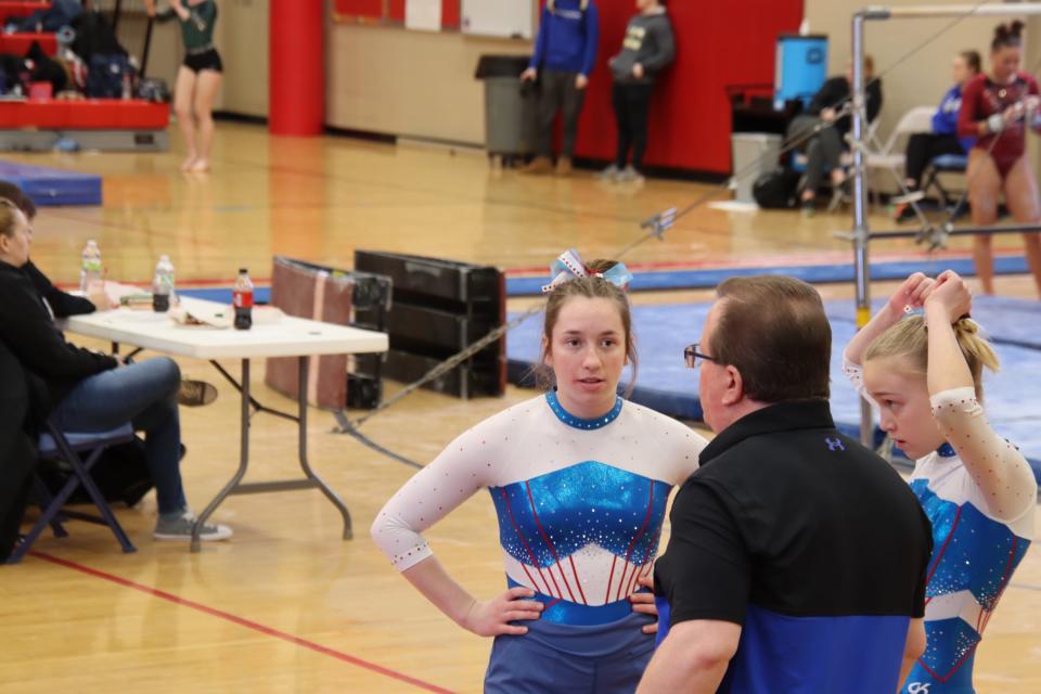 Lincoln rising senior Anna Leuning talks with Coach Les Coin at a gymnastics meet.