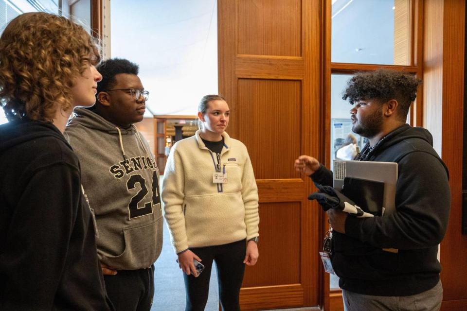 DJ Yearwood, right, a youth advocate, talks to a group of high school seniors including Abi Storjohann, 17, from left, Reggie Locke,18, and Piper Keltner, 18, about the KC Youth and Young Adult Commissions for the City of Kansas City during a student event with American Public Square on Wednesday, Feb. 28, 2024, at the Central Library in Downtown Kansas City.Yearwood would like to get more young adults involved in civic engagement in Kansas City Storjohann and Keltner are students at Belton High School, and Locke is a student at University Academy. Tammy Ljungblad/tljungblad@kcstar.com