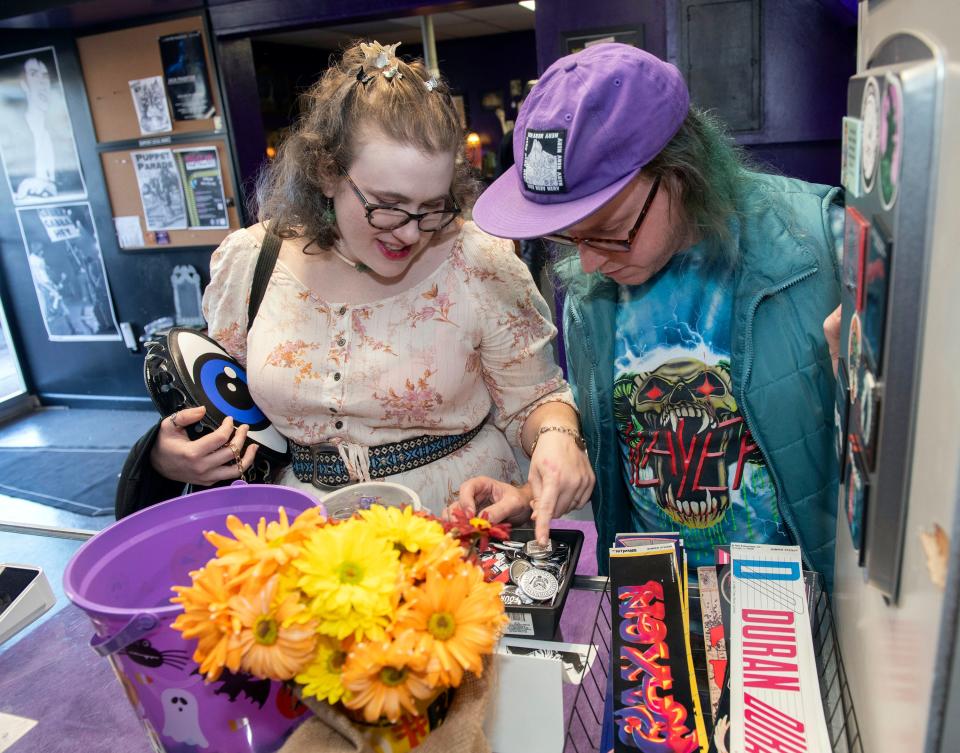 Citrine Norton and Johnie Palmer look through a collection of vintage music pins and stickers while shopping at Pensacola's new goth shop, Phantasma, on Wednesday, Nov. 8, 2023. Phantasma specializes in goth, punk, industrial fashions and other oddities.