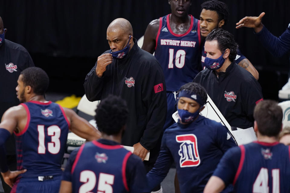 FILE- In a Dec. 4, 2020 file photo, Detroit Mercy head coach Mike Davis prepares to talk to his team during the first half of an NCAA college basketball game against Michigan State, in East Lansing, Mich. In a college basketball season unlike any other, players have had to adjust to coronavirus protocols and just general anxiety about what's to come. Even for those who manage to avoid catching the virus, the mental strain can be a real issue. Detroit Mercy's men's basketball program paused activities earlier this season, citing the mental health of its players. (AP Photo/Carlos Osorio, File)