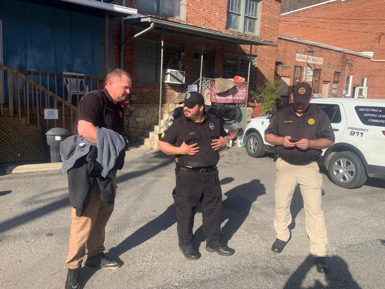 Madison County law enforcement officers, including Marshall Sgt. Kenny Brown, center, and Madison County Sheriff's Office Lt. Coy Phillips were at 20 S. Main Street in Marshall March 26 to perform an investigation of Thomas Fecke's residence.