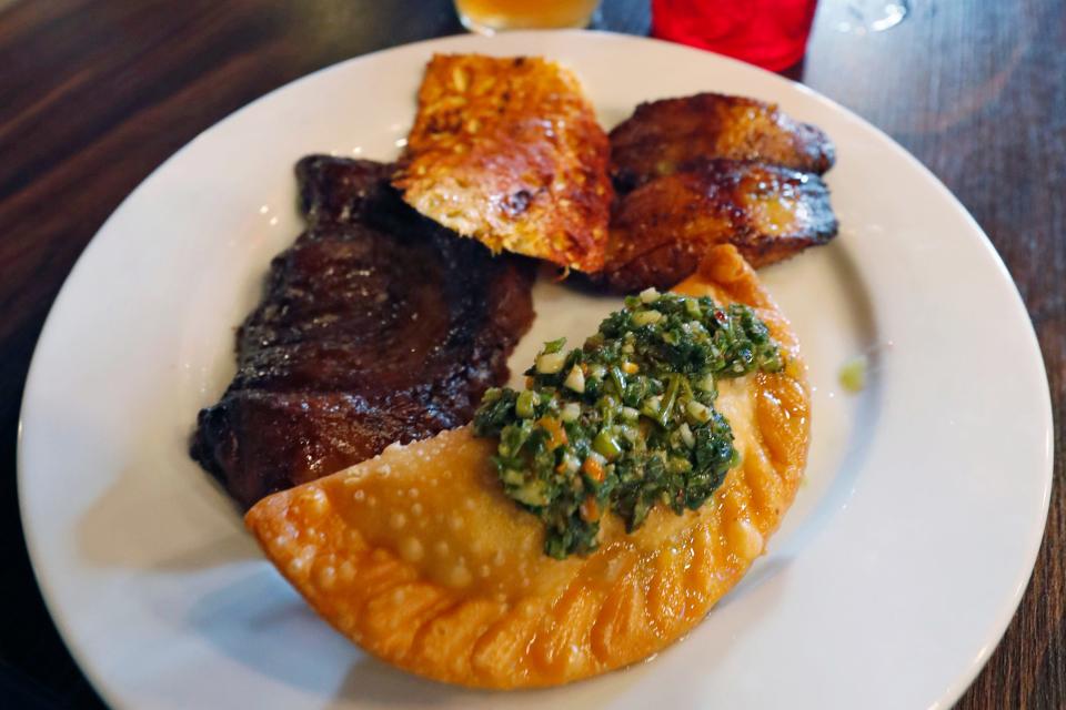 A plate of fresh cut sirloin, with pineapple, plantains and an a beef empanada with chimichurri at Flama Brasilan Steak House on Oglethorpe Avenue in Athens, Ga., on Thursday, Feb. 29, 2024.