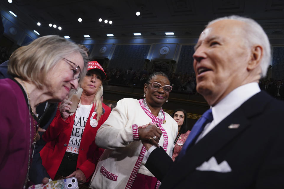 President Joe Biden, right, arrives to deliver the State of the Union address to a joint session of Congress at the Capitol, Thursday, March 7, 2024, in Washington. Looking on at second left is Rep. Marjorie Taylor Greene, R-Ga. (Shawn Thew/Pool via AP)