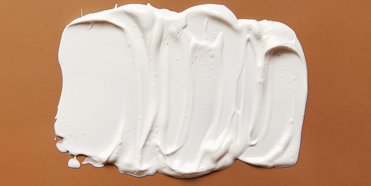 frottis blanc de crème ou d'huile sur fond beige pastel style plat