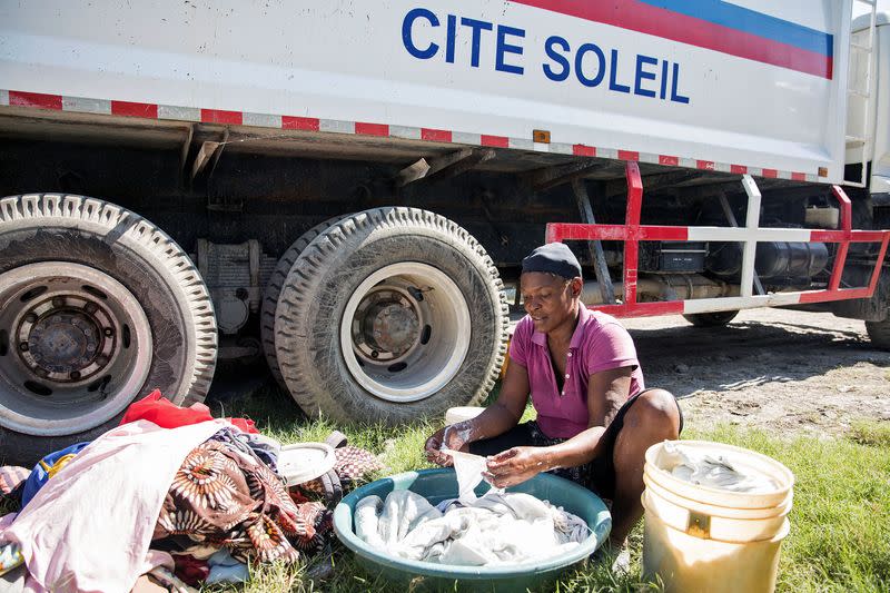 Oslene Estiverne lava su ropa en un campamento en el patio del ayuntamiento de Cité Soleil en Puerto Príncipe