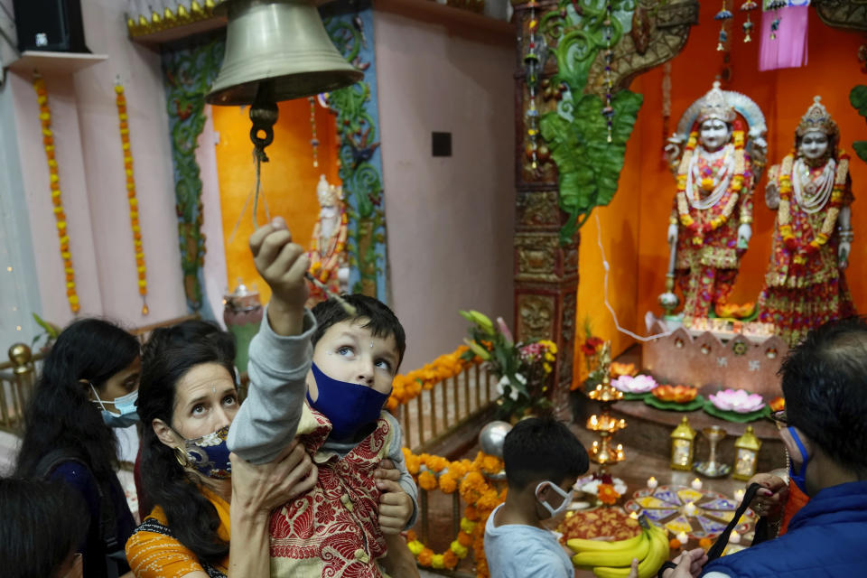Hindu devotees ring a bell as they pray at a temple during Diwali, the festival of lights, in Hong Kong, Thursday, Nov. 4, 2021. Diwali is one of Hinduism's most important festivals, dedicated to the worship of the goddess of wealth Lakshmi. (AP Photo/Kin Cheung)