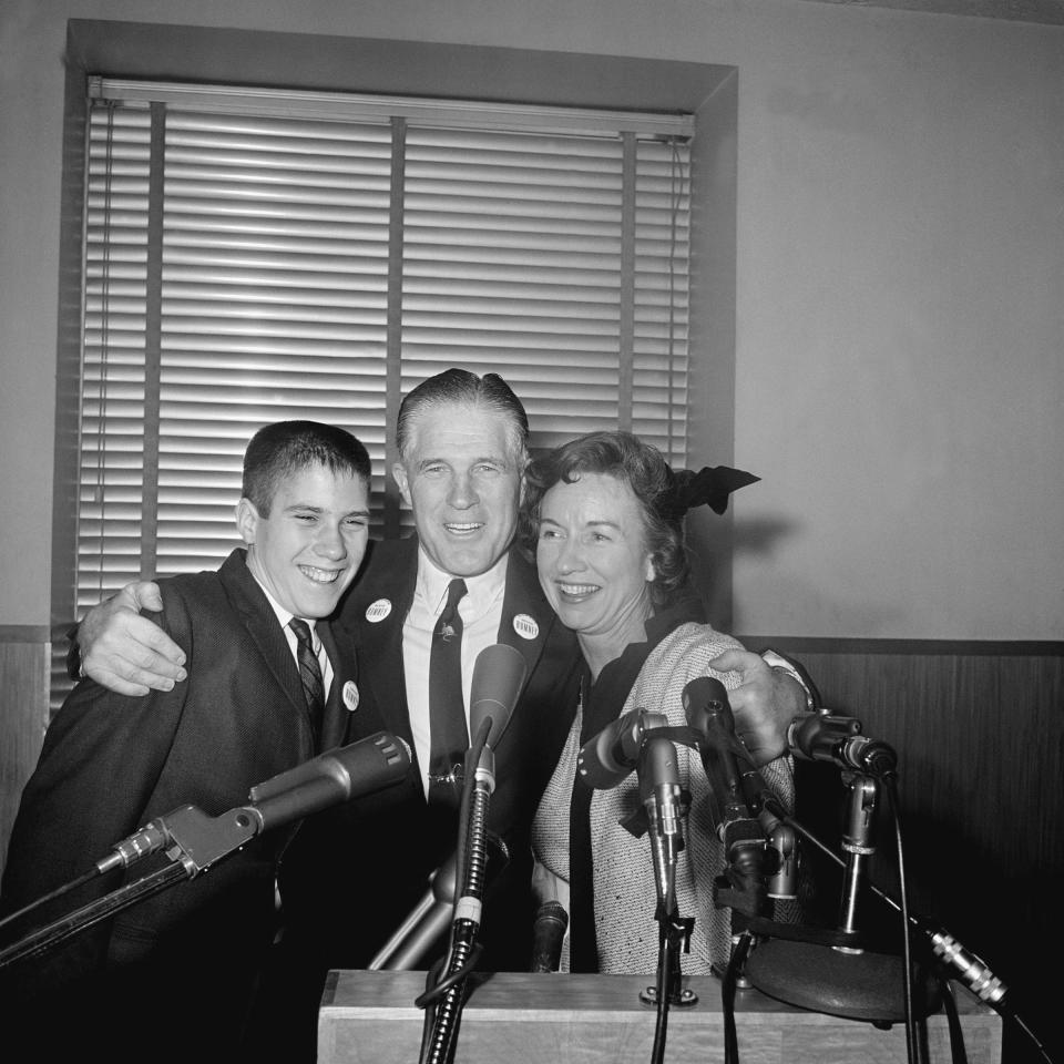 FILE - Industrialist George Romney poses for a photo as he hugs his wife Lenore and son Mitt, 14, at a Detroit news conference Feb. 10, 1962 after he announced he would seek the Republican nomination for Governor of Michigan. (AP Photo, File)