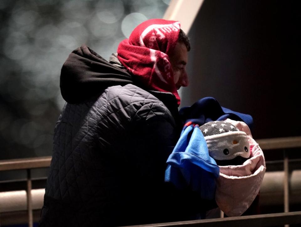 A man carries a baby ashore at Dover (Gareth Fuller/PA) (PA Wire)