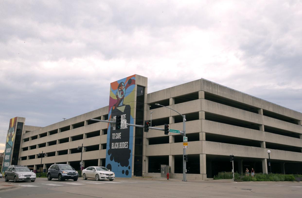 Cars drive past a parking structure near the intersection of Burlington and Clinton streets Sunday, June 2, 2024 in downtown Iowa City, Iowa.