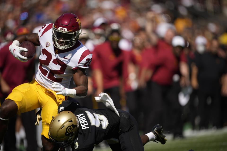 USC running back Darwin Barlow is tackled by Colorado safety Mark Perry