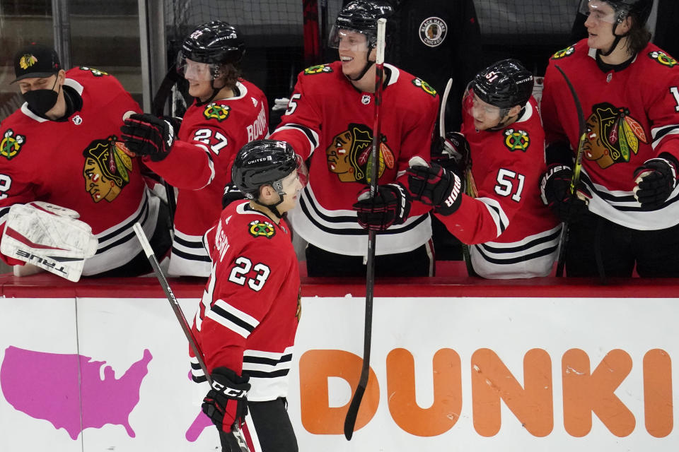 Chicago Blackhawks' Philipp Kurashev (23) celebrates with teammates after scoring a goal in a shootout of an NHL hockey game against the Tampa Bay Lightning in Chicago, Friday, March 5, 2021. (AP Photo/Nam Y. Huh)